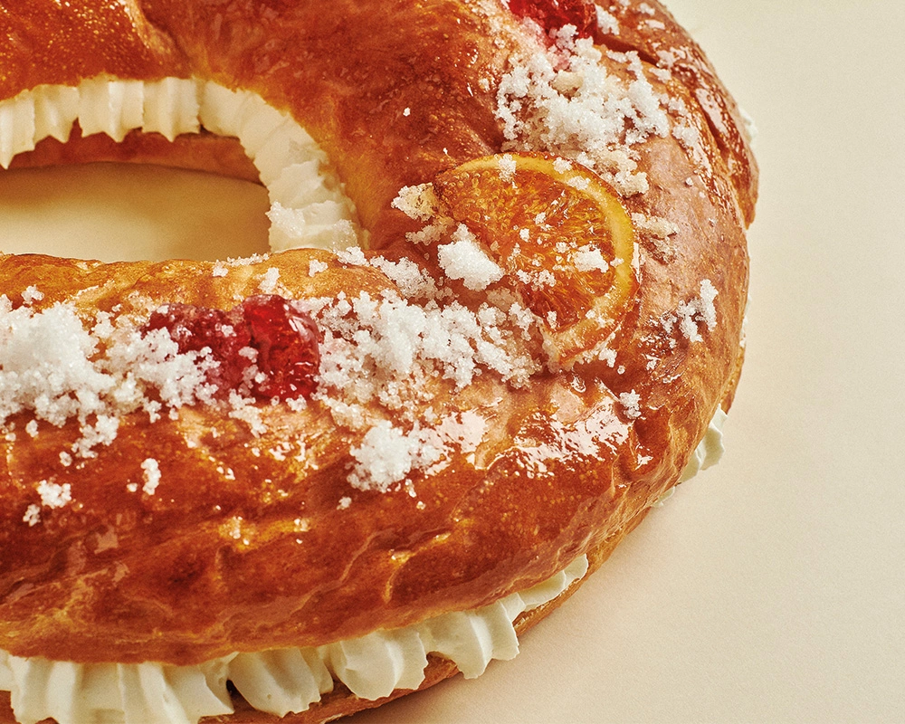 Macarons apilados con fondo beige y rama seca